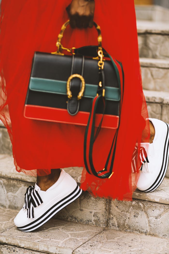 about-02 Fashionable woman in red dress with stylish bag and shoes on stairs.